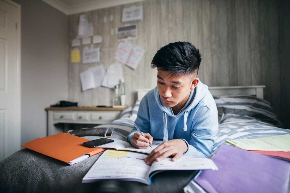 boy in room doing homework