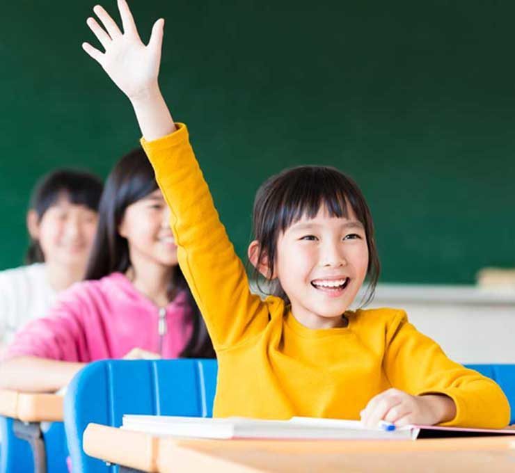 Girl-in-classroom-in-yellow-with-arm-raised Girl in classroom in yellow with arm raised