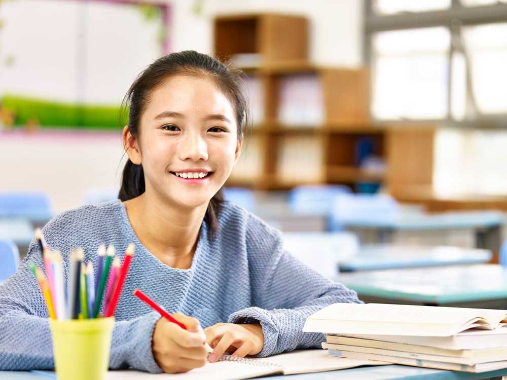 girl in blue doing homework